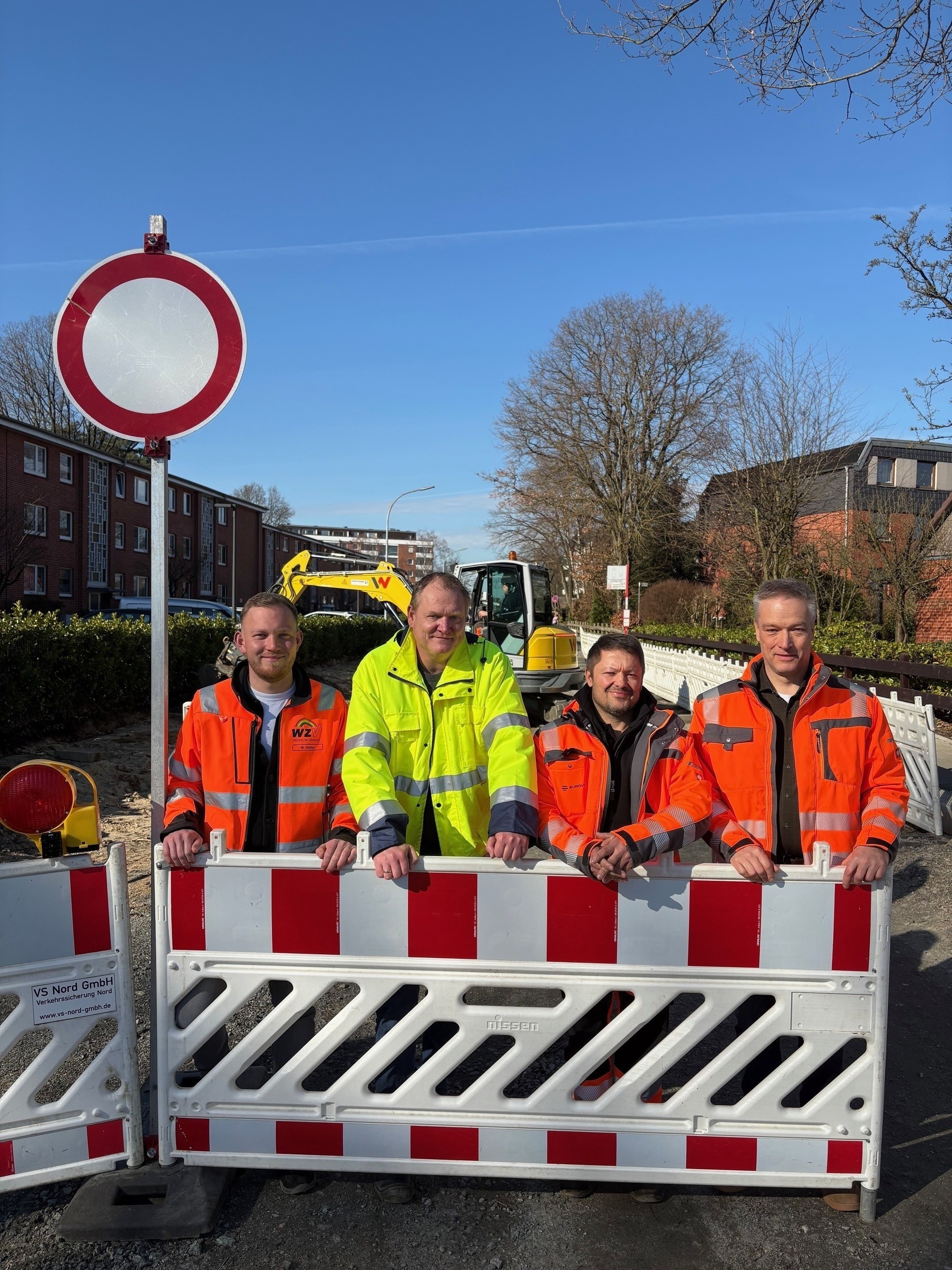 Baubeteiligte stehen vor einer Leitplanke