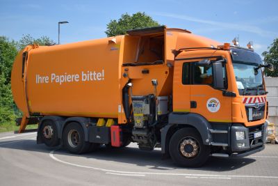  Ein Abfallsammelfahrzeug in orange mit der Aufschrift 